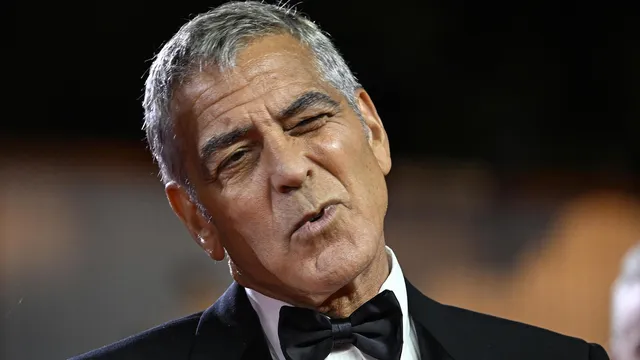 George Clooney appeared on the red carpet in Venice despite an infection that prevented him from speaking.